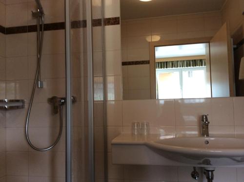 a bathroom with a shower and a sink and a mirror at Zimmervermietung Babsy in Zell am See