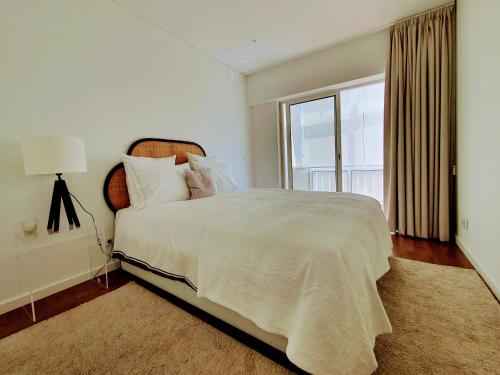 um quarto com uma cama grande e uma janela em Praça do Chile Deluxe by Lisbon Village Apartments em Lisboa