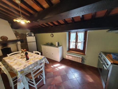 a kitchen with a table and a kitchen with a refrigerator at Casa Giogo in Arezzo