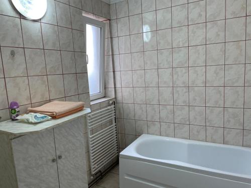 a bathroom with a white tub and a window at Casa Rosi - Oradea in Oradea