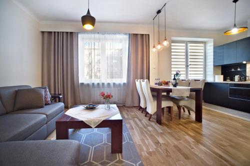 - un salon avec un canapé et une table à manger dans l'établissement P&O Serviced Apartments METRO MOKOTOW, à Varsovie