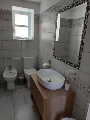 a bathroom with a sink and a toilet and a mirror at Sapore di Sale - Sicily Rooms in Siracusa