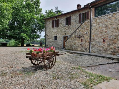 a wheelbarrow filled with flowers in front of a building at Casa Giogo in Arezzo