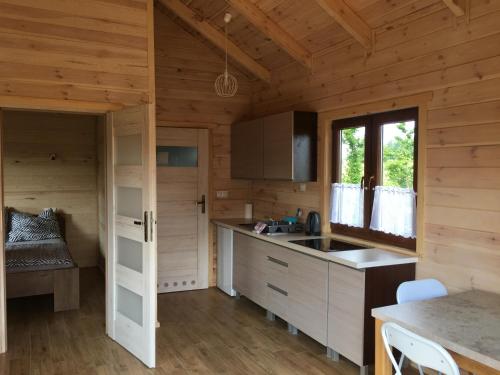 a kitchen in a log cabin with a sink and a window at Przytulisko na Mazurach in Ruciane-Nida