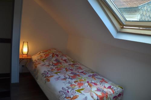 a bed in a room with a window and a lamp at Mère Elvira in Lourdes
