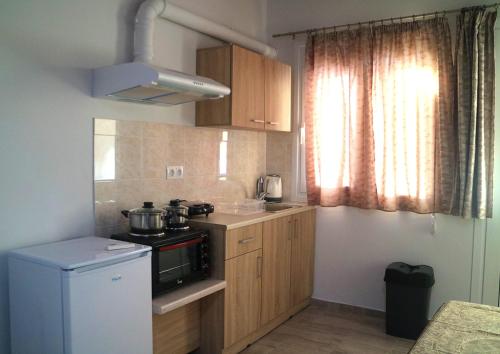 a small kitchen with a stove and a refrigerator at Christos Family Apartments Α in Agios Rokkos