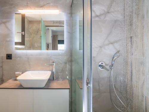 bagno con lavandino e doccia con specchio di Villa Olive Green ad Argásion