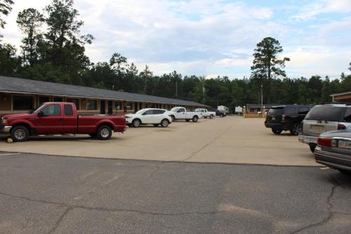 a parking lot with cars parked in front of a building at Evergreen Inn and R.V. in Winnfield