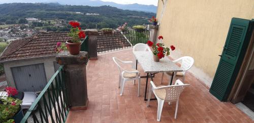 a patio with a table and chairs on a balcony at Casa sotto il Castello in Monti di Licciana Nardi