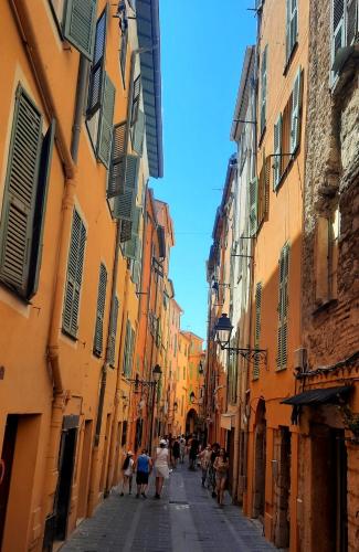 a group of people walking down a street between buildings at MENTON, centre historique, vue mer in Menton