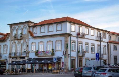 un gran edificio blanco con coches estacionados frente a él en Raiano Guest House en Monção