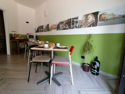 una mesa y sillas en una habitación con una pared verde en B&B Armonia, en Verona