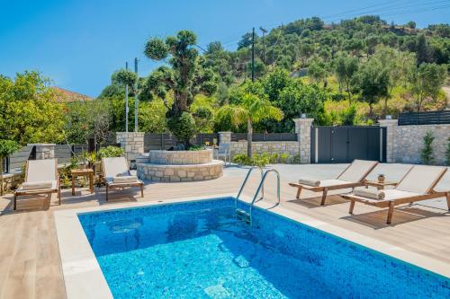 a pool with chairs and a patio with a fire pit at Villa Olive Green in Argassi