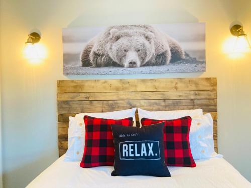 a bed with two pillows and a picture of a bear at Blue Mountain Creekside Studio at North Creek Resort in Blue Mountains