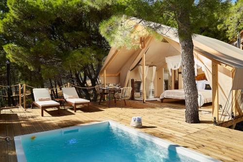 a backyard with a swimming pool and a tent at Abeille Maison Glamping Resort Zlatni Rat -Adults Only in Bol