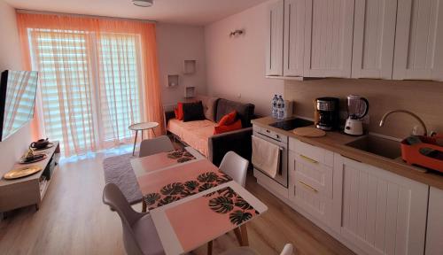 a kitchen and living room with a couch and a table at Apartament Comfort Del Mar III Kołobrzeg in Kołobrzeg