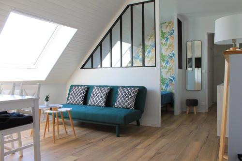 un salon avec un canapé bleu et une fenêtre dans l'établissement Cabourg - Studio cosy à 1 min de la plage, à Cabourg