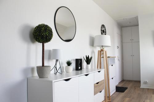 a white room with a mirror and a table with plants at Cabourg - Studio cosy à 1 min de la plage in Cabourg