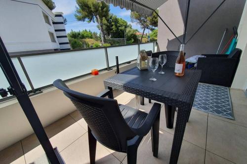 une table noire et des chaises sur un balcon dans l'établissement Riviera Sun Standing Studio, à Villeneuve-Loubet