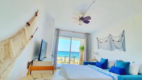 Habitación con cama, sofá y ventana en Cozy beach-front studio with amazing sea view, en Empuriabrava