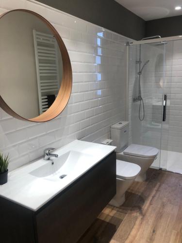 y baño con lavabo, aseo y espejo. en Hostal Sant Marti premium, en Puig-reig