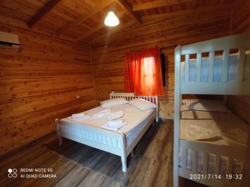 a bedroom with a bed and two bunk beds at Kompleksi Turistik EDIR in Orikum
