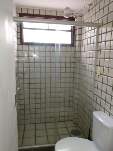 a bathroom with a shower with a toilet and a window at Flat no hotel fazenda portal de Gravatá in Gravatá