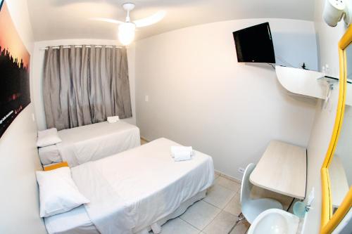 a hospital room with two beds and a tv at Esquina Batel - Hotel Econômico in Curitiba