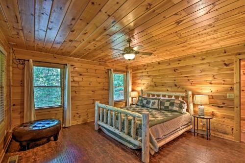 a bedroom with a bed in a log cabin at Cozy Sunset View Cabin with Game Room and Mtn Views! in Ellijay