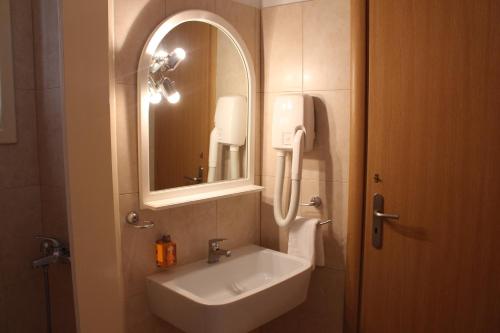 a bathroom with a sink and a mirror at Hotel Kamari in Kamarai