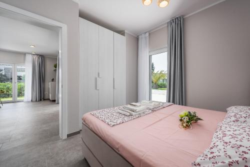 a bedroom with a large pink bed with flowers on it at Casa Del Sole Portoroz in Portorož