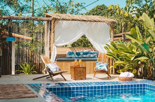 a pool with two chairs and a pergola next to a swimming pool at VILA TRANCOSEAR in Trancoso