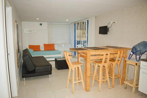 cocina y sala de estar con mesa y sillas en APARTAMENTO EN EL LAGUITO, CARTAGENA, en Cartagena de Indias