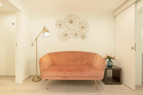 a orange couch in a living room with a lamp at Cosy Duplex House in Downtown Lisboa in Lisbon