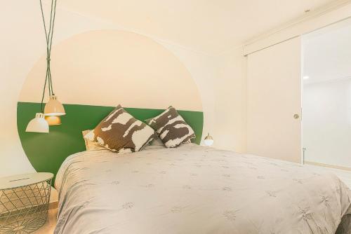 um quarto com uma cama grande e uma cabeceira verde em Cosy Duplex House in Downtown Lisboa em Lisboa