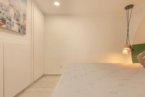 a bedroom with a bed and a painting on the wall at Cosy Duplex House in Downtown Lisboa in Lisbon