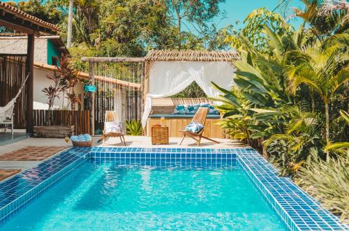 a swimming pool in a backyard with two chairs and a tent at VILA TRANCOSEAR in Trancoso