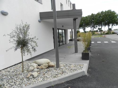 a pile of rocks in front of a building at B&B HOTEL Aubenas in Saint-Didier-sous-Aubenas