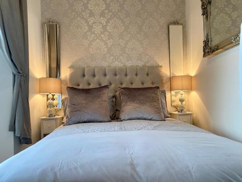a bedroom with a large bed with two lamps at The Sleeping Lion - Dunoon Holiday Home in Dunoon
