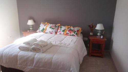 a bedroom with a white bed with towels on it at Casimiro Casa de Campo - Guest's house in Colonia Carlos Pellegrini