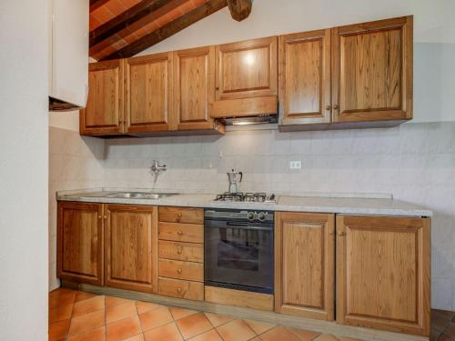 a kitchen with wooden cabinets and a stove at Varna Charm Tuscan Getaway in Querce