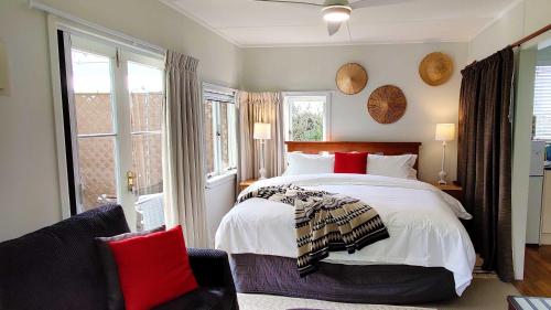 a bedroom with a large bed and a chair at Moon Gate Villa in Kerikeri