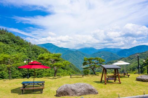 a group of picnic tables with a view of mountains at Gurye Junsung Resort in Gurye