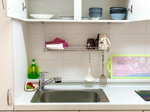 a kitchen sink with a shelf above it at Gurye Junsung Resort in Gurye