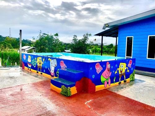 a painted bench in front of a blue building at Deena Homestay (Utan Aji) in Kangar