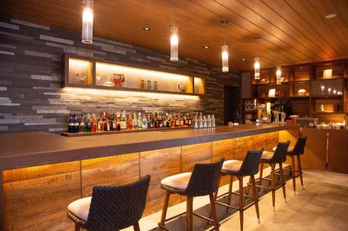 a bar with chairs and a counter with drinks at Hotel Ichibata in Matsue