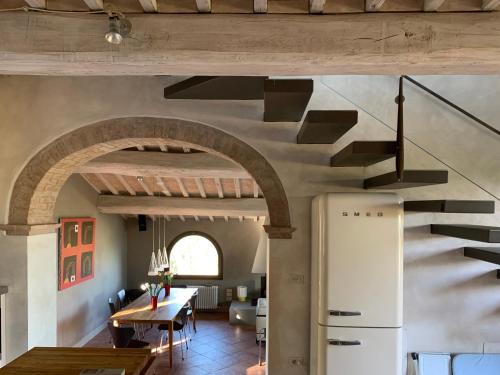 タヴァルネッレ・ヴァル・ディ・ペーザにあるPoggiosoleのキッチン、螺旋階段付きのダイニングルーム