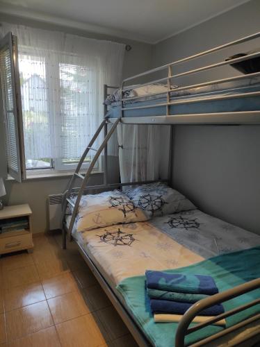 a bedroom with two bunk beds and a ladder at Leukozja in Krynica Morska