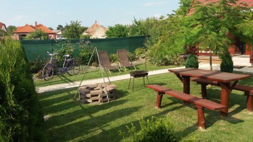 a picnic table and a swing in a garden at Levendula Ház in Lipót