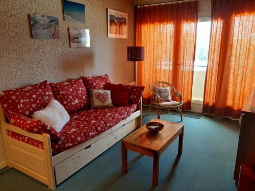 a living room with a red couch and a table at Appartement Villard-de-Lans, 2 pièces, 6 personnes - FR-1-515-31 in Villard-de-Lans